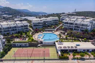 Yorqin Alanya kvartirasining oq kafel pollari, zamonaviy oshxonasi va balkonga chiqish imkoniyati mavjud bo'lgan yashash maydoni, tetiklantiruvchi muhit yaratadi.