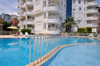 Alanya mulkidagi balkonning Dim daryosi, shahar binolari va tiniq moviy osmonni namoyish etuvchi ko'rinishi.