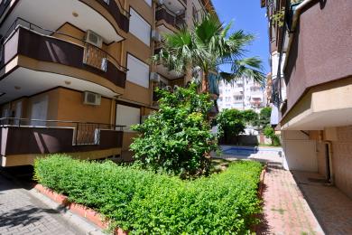 Alanya property features a balcony with tile flooring, wrought iron railing, and a bright, sunny atmosphere.