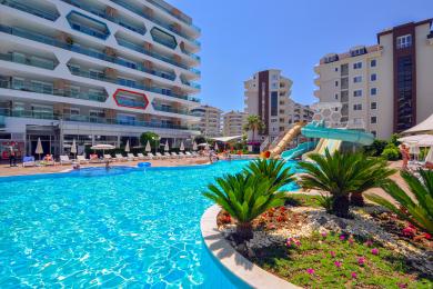Alanya mulkidagi tol mebellari va basseyn manzarasi bilan jihozlangan balkon, dam olish va yorqin muhitni taqdim etadi.