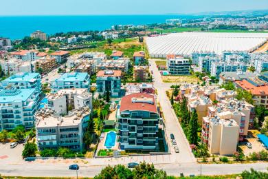Alanya eiendom balkong med glassrekkverk, flislagt gulv og lyse, solrike utsikter.