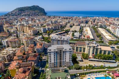 Alanya ejendom stue med et moderne køkken, marmor detaljer, varm belysning og komfortable, stilfulde møbler.