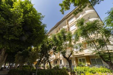 Balkon nekretnine u Alanji sa zidovima obloženim pločicama, tendom i spoljnim trpezarijskim setom, nudi svetle i opuštajuće poglede.