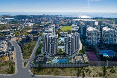 Σαλόνι ακινήτου στην Αλάνια με μοντέρνο πολυέλαιο, μαρμάρινα δάπεδα και έναν άνετο καναπέ σε ουδέτερους τόνους.