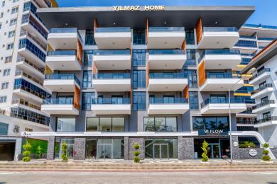 Alanya woning balkon met glazen balustrades, biedt een helder uitzicht op de stad onder een zonnige hemel.