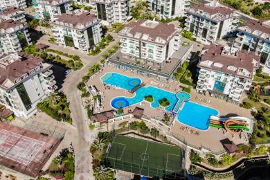 Oq divanlar, zamonaviy oshxona, katta derazalar va iliq, jozibali muhitga ega yorqin Alanya mehmonxonasi.