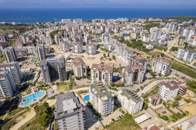 Zonnig Alanya balkon met uitzicht op het zwembad, met een eethoek en een heldere, luchtige sfeer.