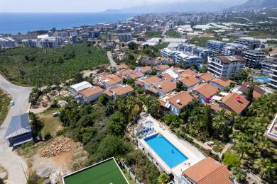 Alanya mulkidagi yog'och tomli, oq mebelli va ajoyib dengiz manzarali balkon, dam olish muhitini yaratadi.