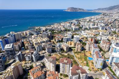 Alanya mulki: Zamonaviy oshxonasi, qulay o'rindiqlari va iliq, jozibali muhiti bilan yorug', ochiq rejadagi yashash maydoni.