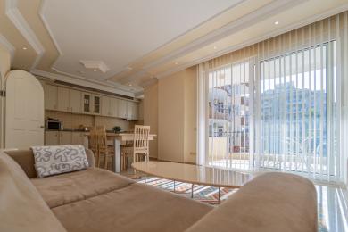 Alanya apartman dnevna soba sa otvorenom kuhinjom, puno svjetla, pristup balkonu i neutralnim, udobnim namještajem.