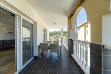 Balkon w Alanyi z ciemną podłogą z płytek, zestawem do spożywania posiłków i malowniczym widokiem na góry.