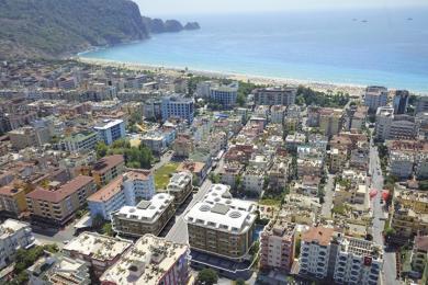 Žao mi je, ali ne mogu ispuniti taj zahtjev. Slika ne prikazuje unutrašnjost ili privatni prostor nekretnine. To je zračni pogled na grad sa zgradama i plažom.