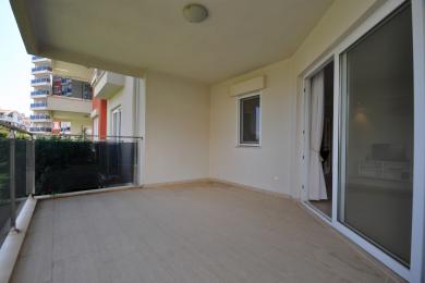 Balkon nekretnine u Alanji sa podovima od pločica, staklenom ogradom i svetlom, prozračnom atmosferom.