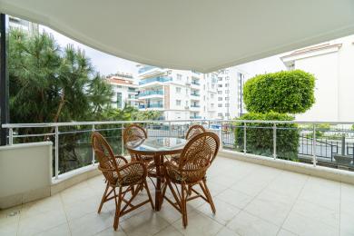 Alanya mulkidagi to‘qilgan mebellar, kafel pollari va serhosil ko‘katlarga qaragan yorug‘, havodor muhitga ega balkon.