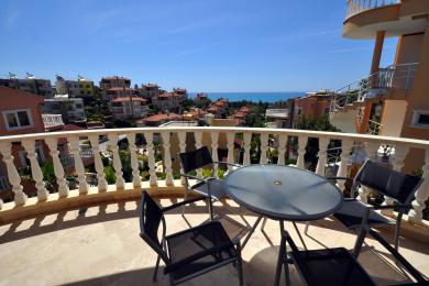 Balkon nekretnine u Alanji s mramornim podom, bijelim ogradama i vanjskim sjedenjem s pogledom na Sredozemno more.
