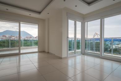 Yorugʻ, boʻsh Alanya xonasi kafel qoplamali va balkon va shahar manzaralarini taqdim etuvchi katta derazalarga ega.
