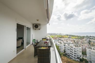 Alanya mulkidagi balkon, to‘qilgan mebellar, kafel pol va ajoyib shahar va dengiz manzaralari.