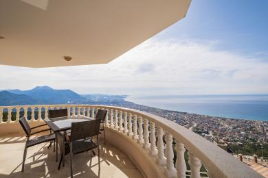 Μπαλκόνι με έπιπλα από ψάθα και εκπληκτική πανοραμική θέα θάλασσας και βουνών στην Αλάνια.