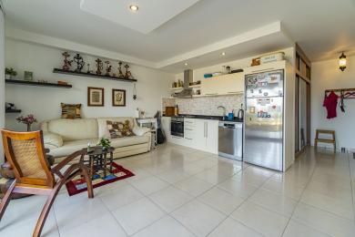 Светъл апартамент с отворен план в Алания, включващ модерна кухня с уреди от неръждаема стомана и удобна всекидневна.