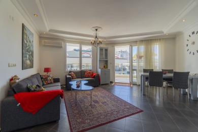 Yorug' Alanya mehmonxonasi kafel pollari, qulay divanlar, qandil va shahar manzaralarini taqdim etuvchi balkon bilan.