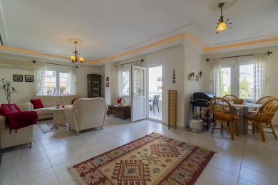 Lichte Alanya woonkamer met tegelvloeren, comfortabele zitplaatsen en toegang tot het balkon, waardoor een ontspannen sfeer ontstaat.