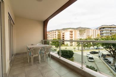 Balkon nekretnine u Alanji sa podovima od pločica, staklenim ogradama i pogledom na grad, stvarajući opuštajući otvoreni prostor.