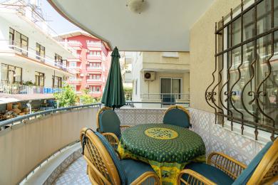 Alanya mulkidagi rattan mebellari, naqshli dasturxon va yorqin kunduzgi yorug'lik bilan jihozlangan balkon, qulay ochiq ovqatlanish joyini yaratadi.