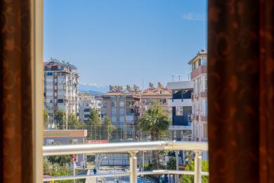 Alanya shahar manzarasining zamonaviy binolar va uzoqdagi tog'lar bilan balkon ko'rinishi.