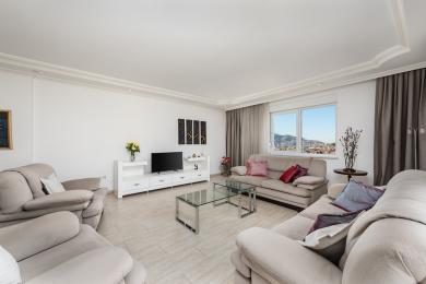 Гасцёўня ва ўласнасці Аланіі з нейтральнымі канапамі, кафлянай падлогай, яркім натуральным святлом і відамі на горад.