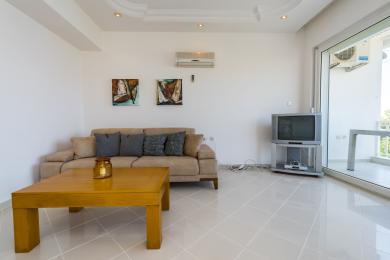 Svijetli dnevni boravak u stanu s pristupom balkonu, s modernim dekorom i udobnim sjedenjem.