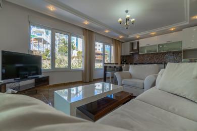 Oq divanlar, zamonaviy oshxona, katta derazalar va iliq, jozibali muhitga ega yorqin Alanya mehmonxonasi.