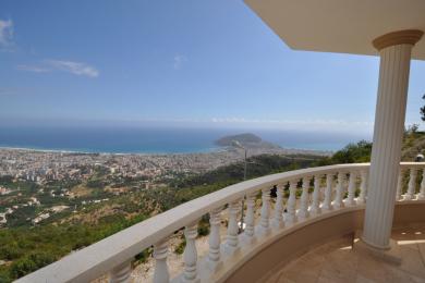 Balkon nekretnine u Alanji s mramornom balustradom nudi panoramski pogled na grad i Sredozemno more.