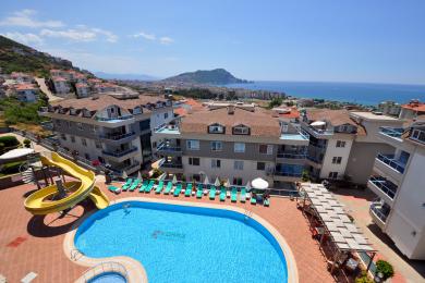 Alanya mulki slayd, quyosh stullari va ajoyib dengiz manzaralari bilan yorqin basseyn maydoniga ega.
