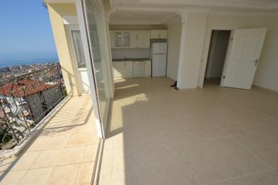 Yorug' Alanya kvartirasi ochiq oshxona, kafel qoplamasi va ajoyib dengiz manzarali balkon bilan ajralib turadi.