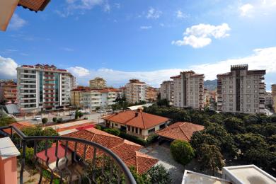 Pogled s balkona nekretnine u Alanji koji prikazuje arhitekturu grada pod vedrim, sunčanim nebom.